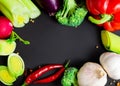 Fresh vegetables: broccoli, celery, leek, red onion, chili pepper, sweet red pepper, radishes and garlic. Black background with