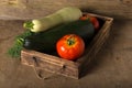 Fresh vegetables in a burned rustic texture box for background. Rough weathered wooden board Royalty Free Stock Photo