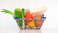 Fresh vegetables in a cart from a supermarket on a white background, natural fresh tomatoes and natural cheese, lemon, head Royalty Free Stock Photo