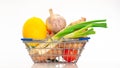 Fresh vegetables in a cart from a supermarket on a white background, natural vegetables lemon, ginger, with herbs in a shopping Royalty Free Stock Photo