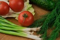 Fresh vegetables on a chopping wooden board, about to turn into a salad. Royalty Free Stock Photo