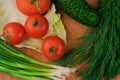 Fresh vegetables on a chopping wooden board, about to turn into a salad Royalty Free Stock Photo