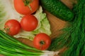 Fresh vegetables on a chopping wooden board, about to turn into a salad Royalty Free Stock Photo