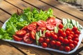 Fresh vegetables closeup: lettuce, tomatoes, cucumbers on a plate on a wooden table Royalty Free Stock Photo