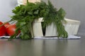 Fresh vegetables cucumbers, tomatoes on the kitchen, gray surface on a linen towel, and green greens dill and parsley are in the Royalty Free Stock Photo