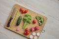 Fresh vegetables on a cutting board on a light wooden table