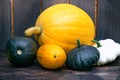 Fresh vegetables on a dark table. Autumn harvest. Yellow pumpkin, squash, squash, green tomatoes Royalty Free Stock Photo