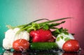 Fresh vegetables with drops of water on a black background, pidor, cucumber, bell pepper, onion, greens