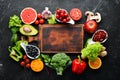 Fresh vegetables and fruits on a black background. Vitamins and minerals. Top view. Royalty Free Stock Photo