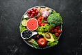 Fresh vegetables and fruits on a black background. Vitamins and minerals. Top view. Royalty Free Stock Photo