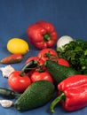 Fresh vegetables and fruits on a blue textile background. Close-up. Selective focus on avocado. Horizontal orientation