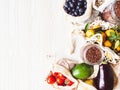 Fresh vegetables and fruits in eco cotton bags and cereals in glass jars on table in the kitchen