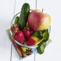 Fresh vegetables and fruits in a glass bowl. Strawberry, apple, cucumber, lemon and mint.