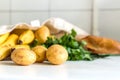 Fresh vegetables and fruits, herbs and baguette in canvas reusable grocery tote bag on the kitchen table