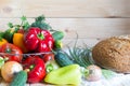 Fresh vegetables and half of bread on wooden table. Natural homegrown and homemade food concept. Royalty Free Stock Photo