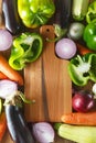 Fresh vegetables and ingredients for cooking around vintage cutting board on rustic background, top view, place for text. Vegan Royalty Free Stock Photo