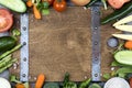 Fresh vegetables and ingredients for cooking around vintage cutting board on rustic background Royalty Free Stock Photo