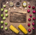 Fresh vegetables ingredients radishes, brussels sprouts, corn, seasoning lined around the cutting board wooden rustic backgroun