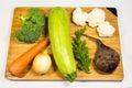 Fresh vegetables lie on a wooden board. Courgettes, carrots, beets, brocali, cauliflower, onions, parsley. Royalty Free Stock Photo