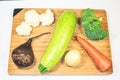 Fresh vegetables lie on a wooden board. Courgettes, carrots, beets, brocali, cauliflower, onions, parsley. Royalty Free Stock Photo