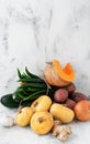 Fresh vegetables for making homemade pumpkin soup on the kitchen table. Close-up, space for recipe text, vertical orientation