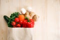Fresh vegetables in paper bag on light wooden background Royalty Free Stock Photo