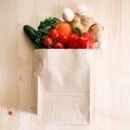 Fresh vegetables in paper bag on light wooden background Royalty Free Stock Photo