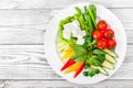 Fresh vegetables plate with feta cheese, cherry tomatoes, cucumber, celery, sweet pepper and basil in a plate on wooden background Royalty Free Stock Photo