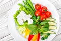 Fresh vegetables plate with feta cheese, cherry tomatoes, cucumber, celery, sweet pepper and basil in a plate on wooden background Royalty Free Stock Photo