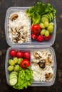 Fresh vegetables and rice with mushrooms in containers closeup on dark background, top view. The concept of healthy eating.