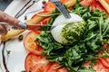 Fresh vegetables salad with white soft burrata cheese and tomatoes, fresh arugula and green pesto. Food recipe background. Close Royalty Free Stock Photo