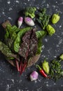 Fresh vegetables - swiss chard, broccoli, pepper, turnip. On a dark background, top view. Royalty Free Stock Photo