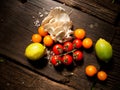 Fresh vegetables on a textured wooden table with sunlight. Top down angle.