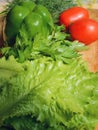 Fresh vegetables, tomato, lettuce, dill, parsley, bell pepper lie on a wooden table. Royalty Free Stock Photo