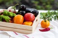 Fresh vegetables, tomatoes, peppers, aubergines, chilli pepper in a wooden box in the open air. Royalty Free Stock Photo