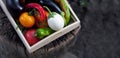 Fresh vegetables, tomatoes, peppers, aubergines, chilli pepper in a wooden box on a stump in the open air in the garden. Royalty Free Stock Photo