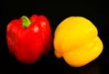 Fresh vegetables Two sweet yellow and red peppers on a black background.Close-up. Royalty Free Stock Photo