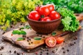 Fresh vegetables on a wooden background. Tomato in a plate on a green background.