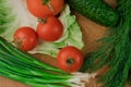 Fresh vegetables on a chopping wooden board, about to turn into a salad Royalty Free Stock Photo