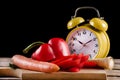 Fresh vegetables on a wooden kitchen board and retro clock on wooden board and desk