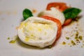 Fresh vegetarian caprese salad, buffalo mozzarella cheese, red tomatoes, olive oil. Italian food served in restaurant, close up Royalty Free Stock Photo