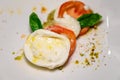 Fresh vegetarian caprese salad, buffalo mozzarella cheese, red tomatoes, olive oil. Italian food served in restaurant, close up Royalty Free Stock Photo