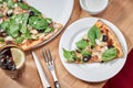 Fresh vegetarian pizza with spinach, black olives and almonds on wooden table in restaurant. Royalty Free Stock Photo