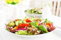 Fresh vegetarian vegetable salad with tomato, onion, cucumber, pepper, basil and lettuce. Salad on plate Royalty Free Stock Photo