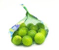 Fresh vibrant green ripe lime or limes fruit in gauze net bag isolated on white background. With clipping path. Round fruit used Royalty Free Stock Photo