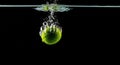 Lime Dropping into Water, Splash and Bubbles, Black Background Royalty Free Stock Photo