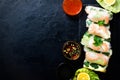 Fresh Vietnamese, Asian, Chinese food frame on black concrete background. Spring rolls rice paper, lettuce, salad Royalty Free Stock Photo