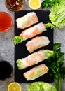 Fresh Vietnamese, Asian, Chinese food frame on grey concrete background. Spring rolls rice paper, lettuce, salad Royalty Free Stock Photo