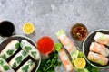 Fresh Vietnamese, Asian, Chinese food frame on grey concrete background. Spring rolls rice paper, lettuce, salad