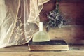 Fresh vintage perfume bottle next to aromatic flowers on wooden table. retro filtered image Royalty Free Stock Photo